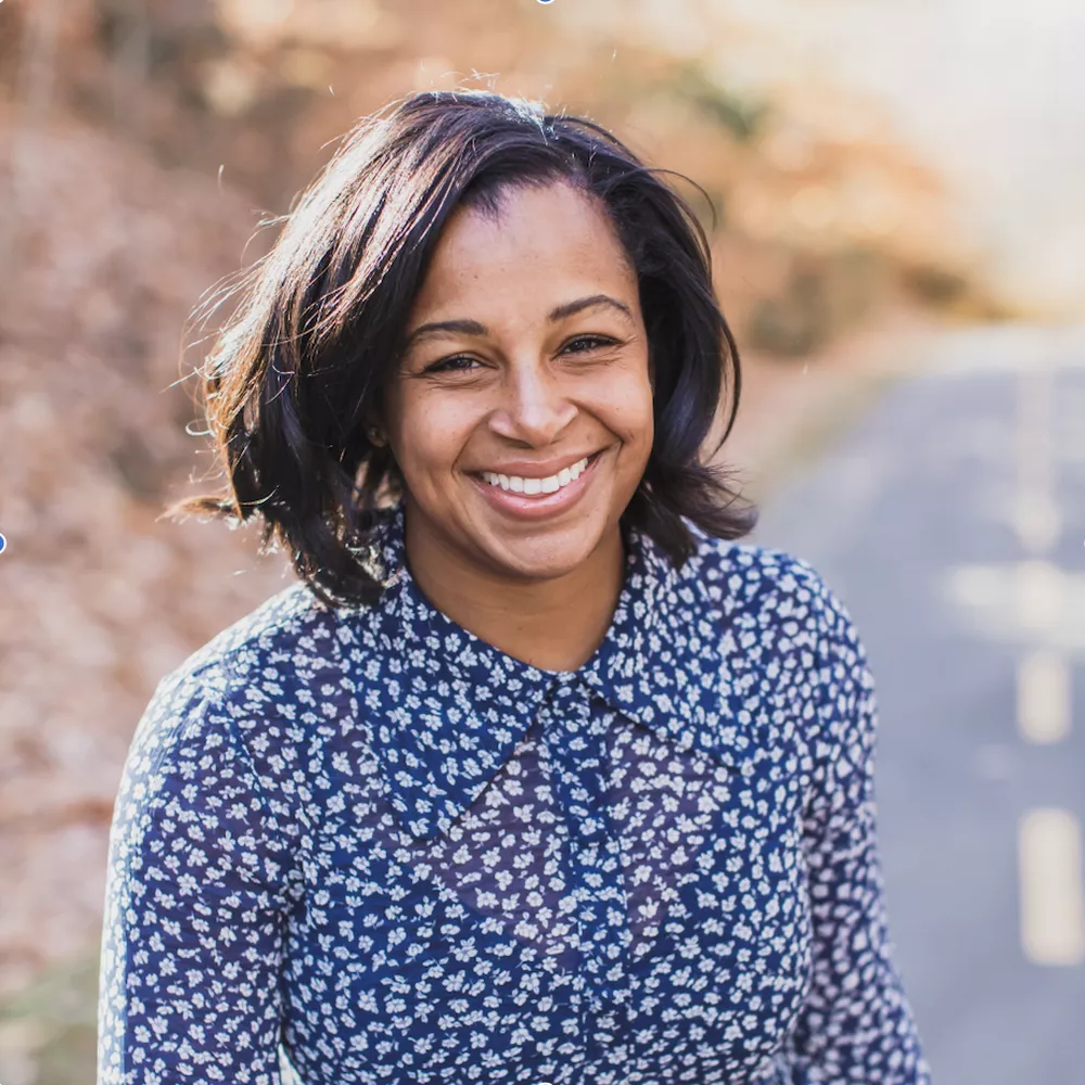 Asha Palmer, SVP of Compliance at Skillsoft seen with a bright smile on her face